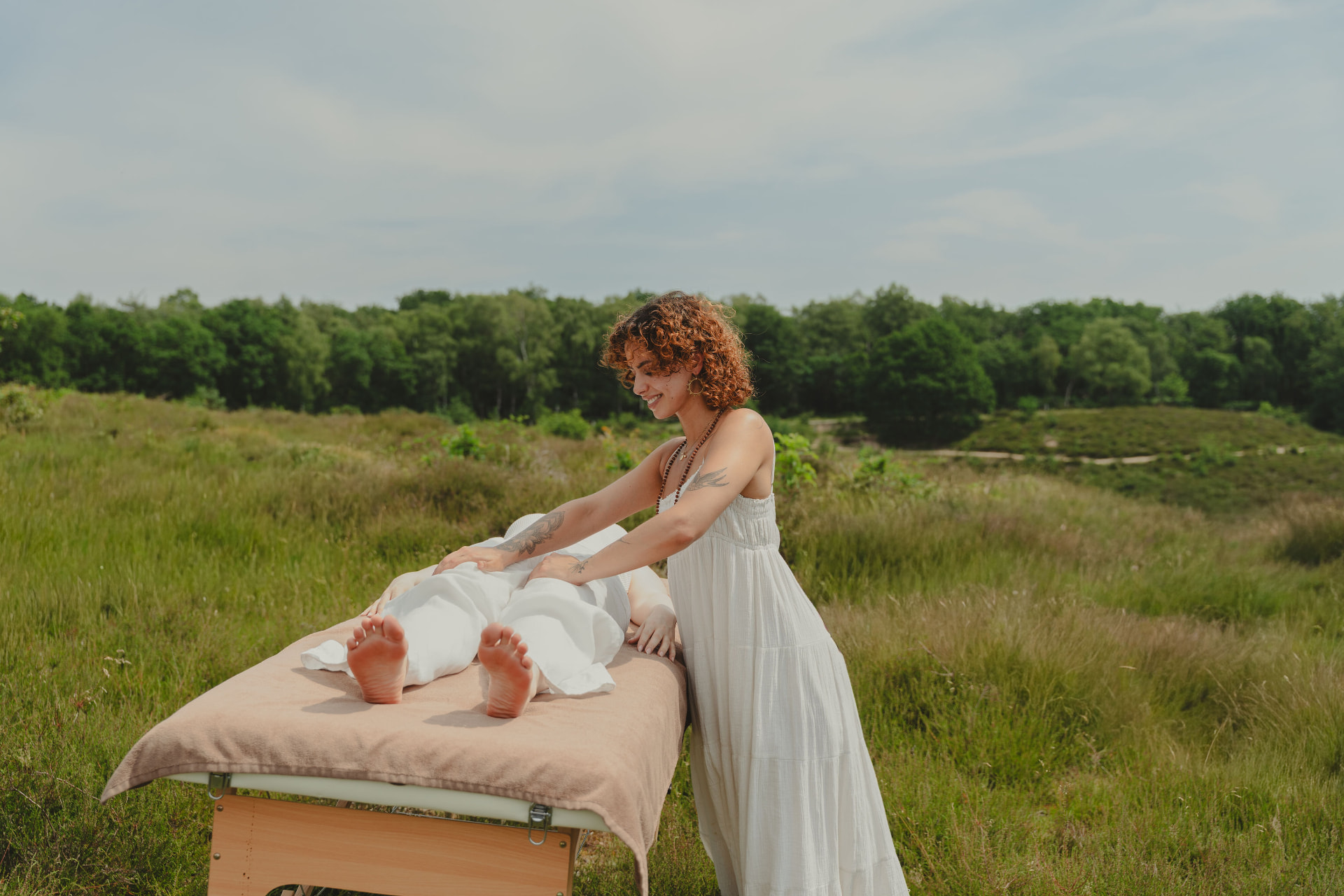 Shani Steg geeft een holistische massage in de buitenlucht op een massagetafel in de natuur